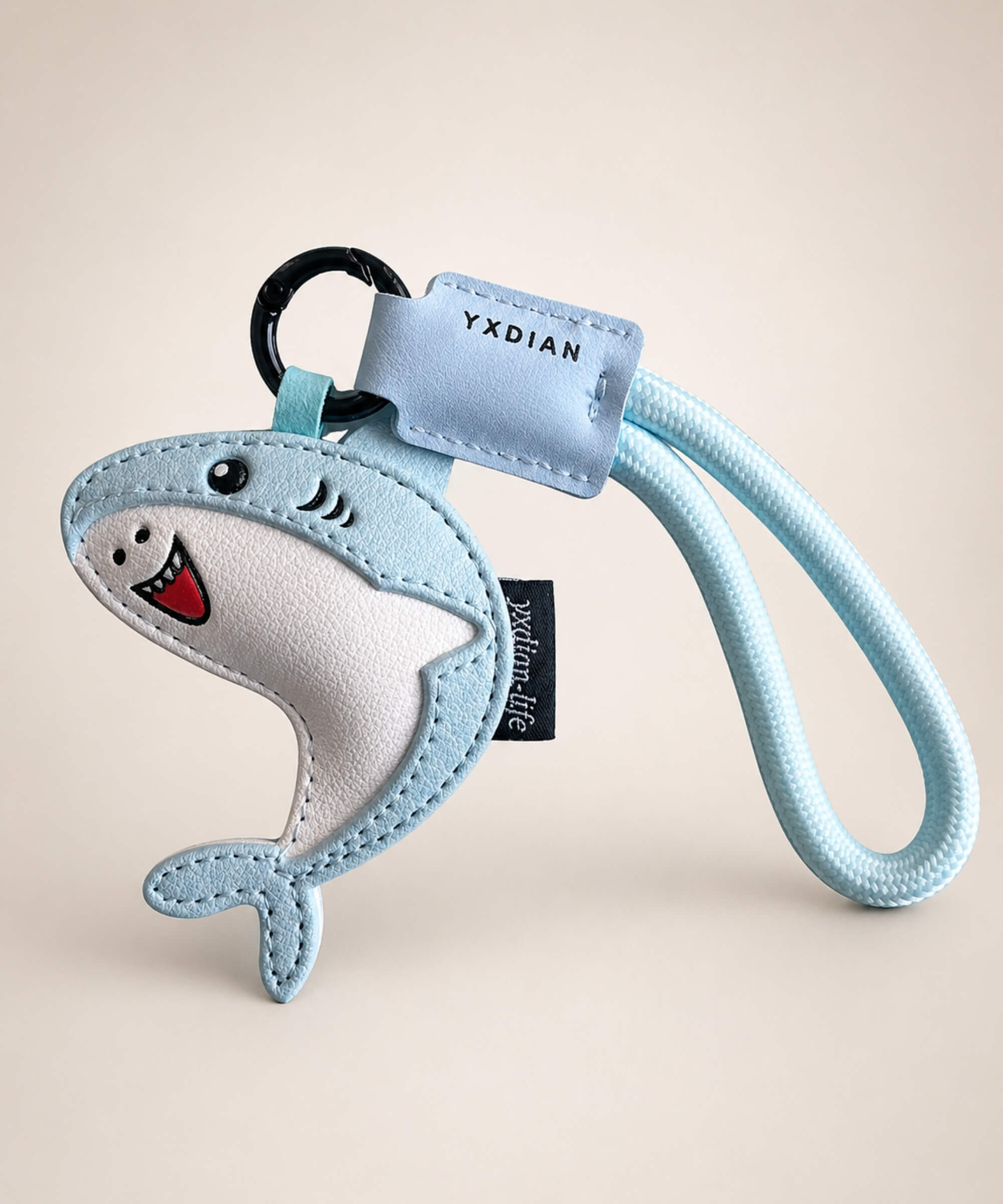 Blue cute shark PU leather keychain with wrist strap on a neutral studio background.